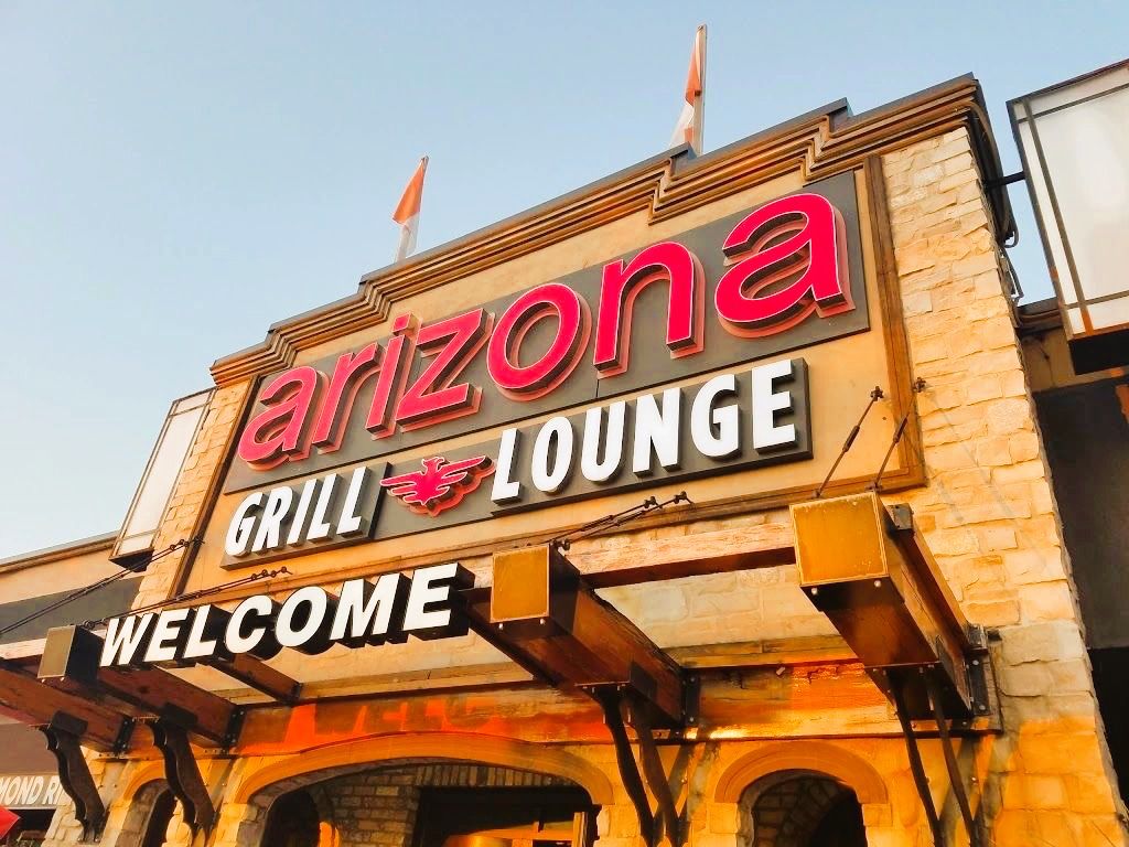 Exterior of Arizona Grill Lounge in Etobicoke with its lit sign above the entrance